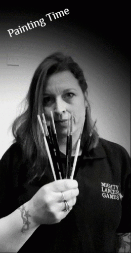 a woman holding a painting brush in her right hand