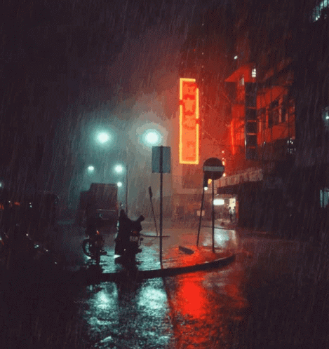a man riding a bike at night on a rainy street