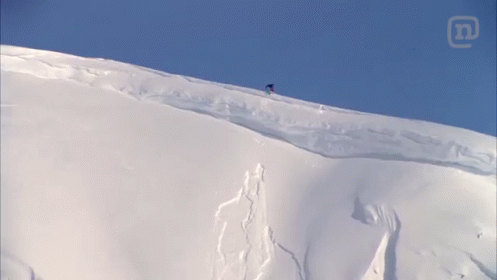 a man snowboarding down the side of a hill