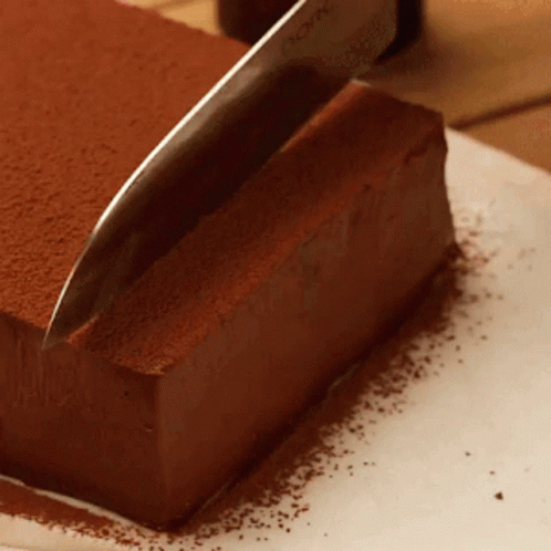 a knife is used to cut into a piece of cake