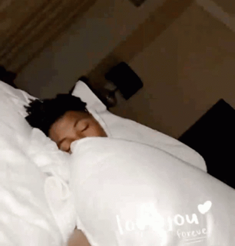 a person covered up in pillows and laying down