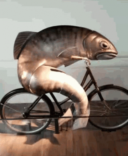 an unusual figurine of a fish riding a bike