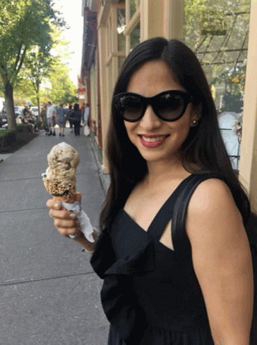 a woman wearing sunglasses and holding an ice cream