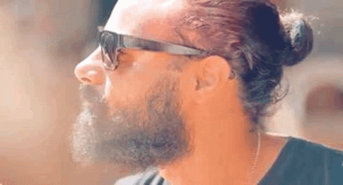 a man with a beard and sunglasses staring to the right