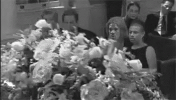 black and white pograph of people on the phone near flower arrangements
