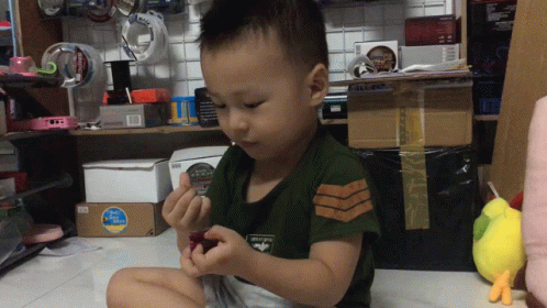 a small boy sits on the floor playing with a toothbrush