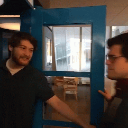 two men are having conversation near glass doors