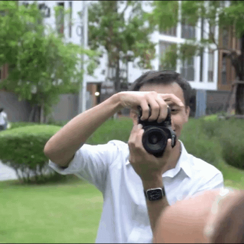 a man taking pictures while looking through his glasses