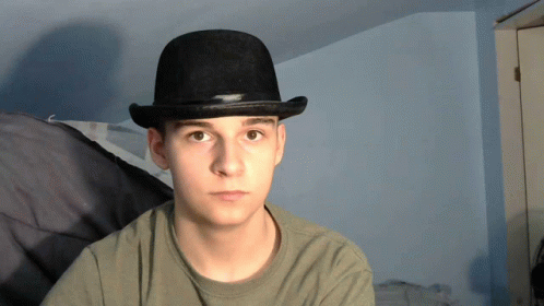 the young man is wearing a brown hat