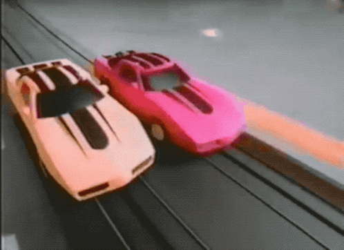 two plastic cars next to each other on a track