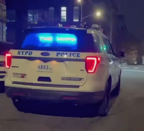 an nypd vehicle driving down the street at night