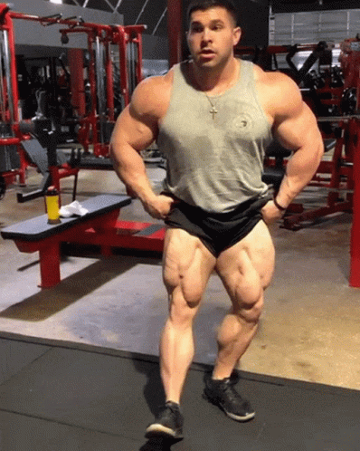 a man standing on the ground wearing shorts and bodybuilding clothes