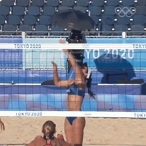 two women are playing volleyball while in the sun
