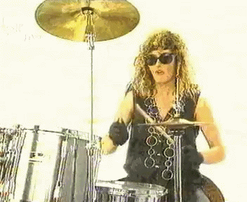 a young woman playing drums in front of a music mixer
