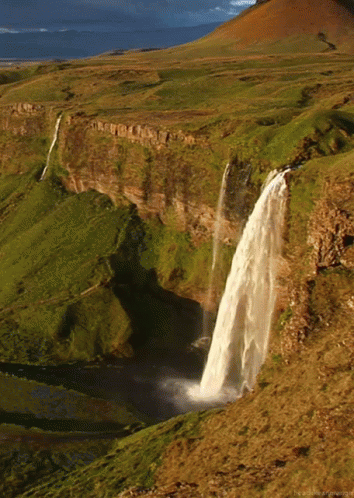an aerial view of a waterfall in a mountain