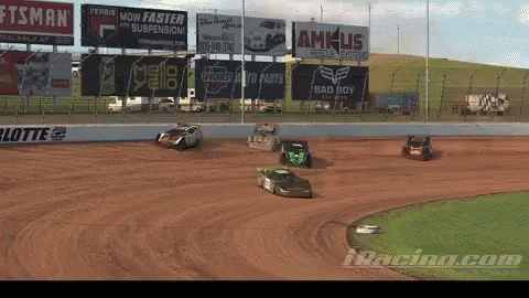 several cars racing around a dirt track during a dirt race