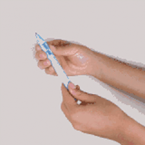 a hand holding two toothbrushes with one toothbrush in it