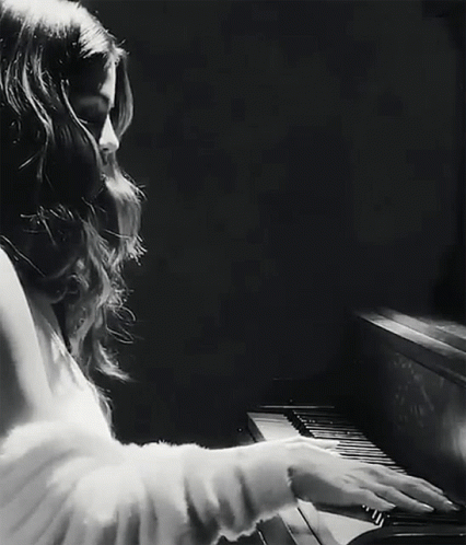 a  playing the piano while wearing a white blouse