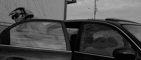 black and white pograph of a man inside of his car
