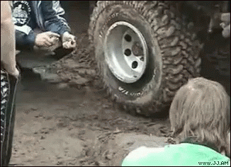 an atv tire being pulled by another man and child