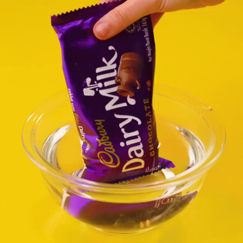 a hand reaching into a bowl with a condom on top