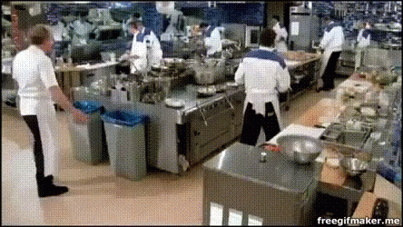 some workers are preparing food in an assembly line