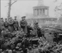 a crowd of men and women gather in front of a large building