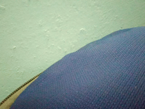 close up of a brown sweater over someone's leg