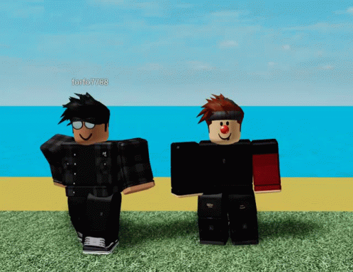 two toy figures wearing black outfits standing on grass
