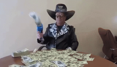 there is a man wearing a cowboy hat and glasses holding out money