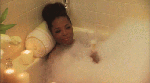 a woman laying down in a bathtub full of bubbles