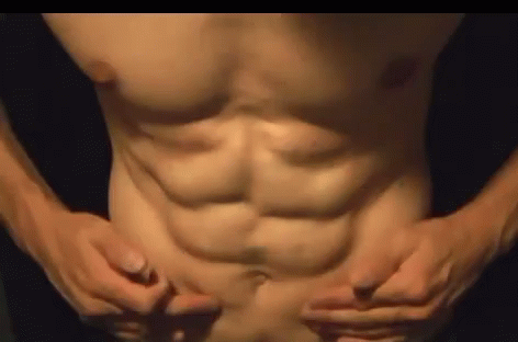 a close up image of a shirtless man with his hands on his chest