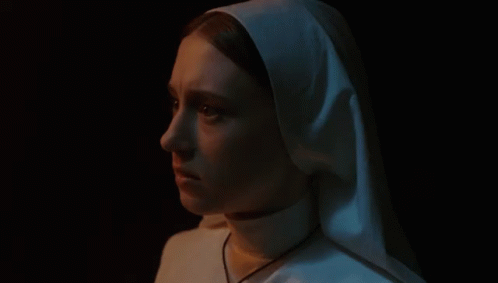 a woman with a white nun outfit on and a black background