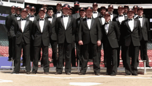 a group of young men dressed in tuxedo are standing together