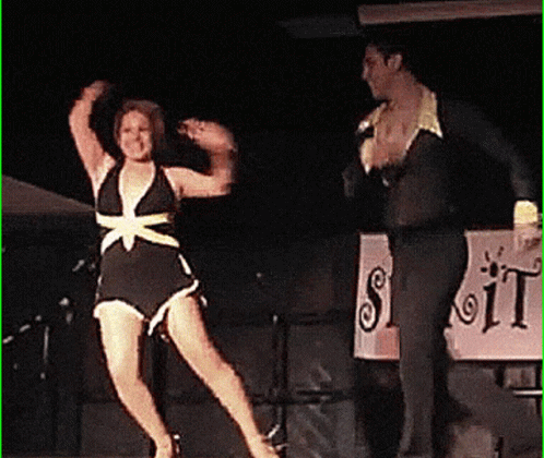 the woman in a bathing suit is dancing on stage