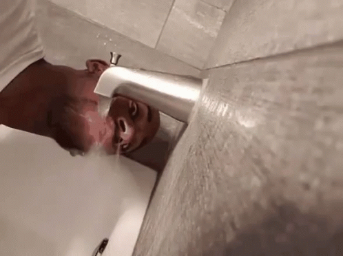 a man is seen using the plunger to reach the sink
