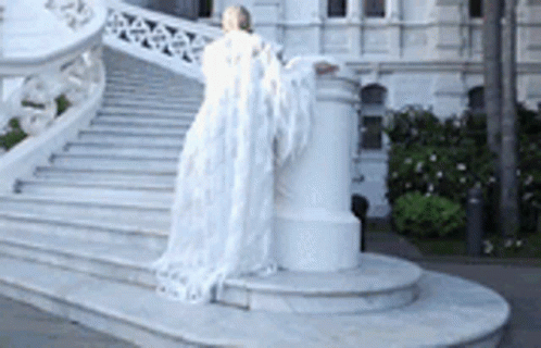 the statue is by the staircase of a building
