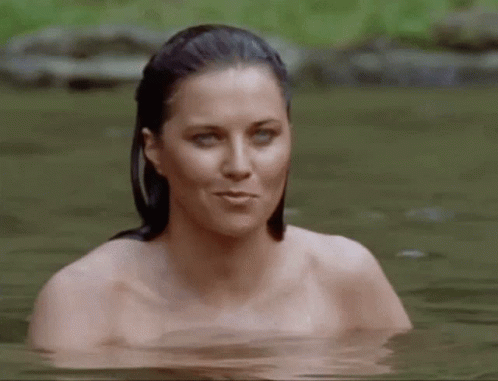 a woman with blue makeup stands in the water