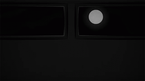 the dark black room shows a clock and three square windows