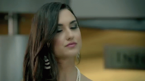 a girl with long dark hair is wearing pearls and pearls