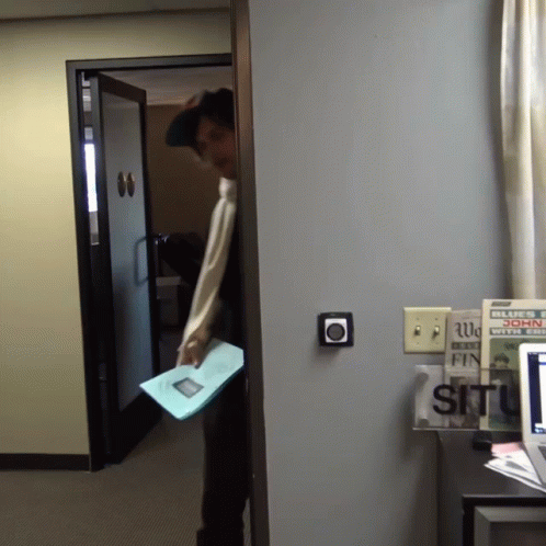 a person opening an office door carrying paper
