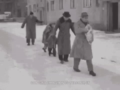 vintage black and white po of people walking down a snowy street