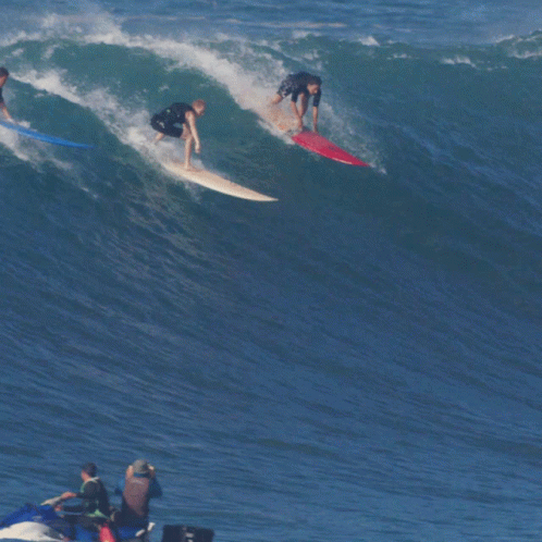 a group of people riding waves on surfboards