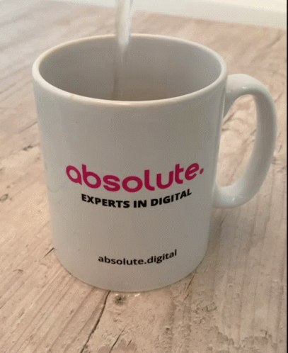 the coffee mug with the word absolute is filled with white liquid