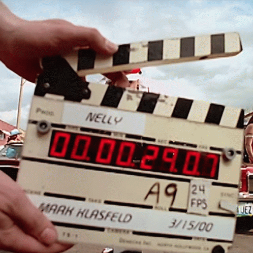 the time is set on a movie clapper, and people are watching it