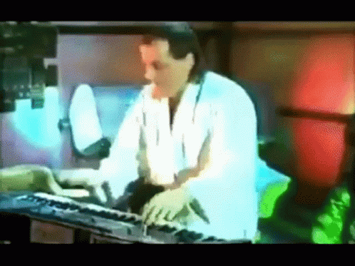 a man on a video screen playing a keyboard
