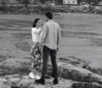 black and white po of a young couple on rocky bank