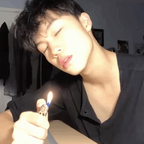 young man using electric cigarette to light up his lips