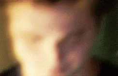 a blurry image of a man's face with his hand on his mouth