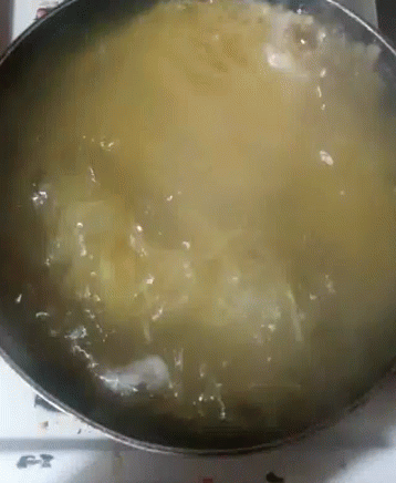 a large metal pan with boiling liquid in it